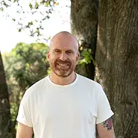 Foto do escritor Matt Haig sorrindo ao ar livre