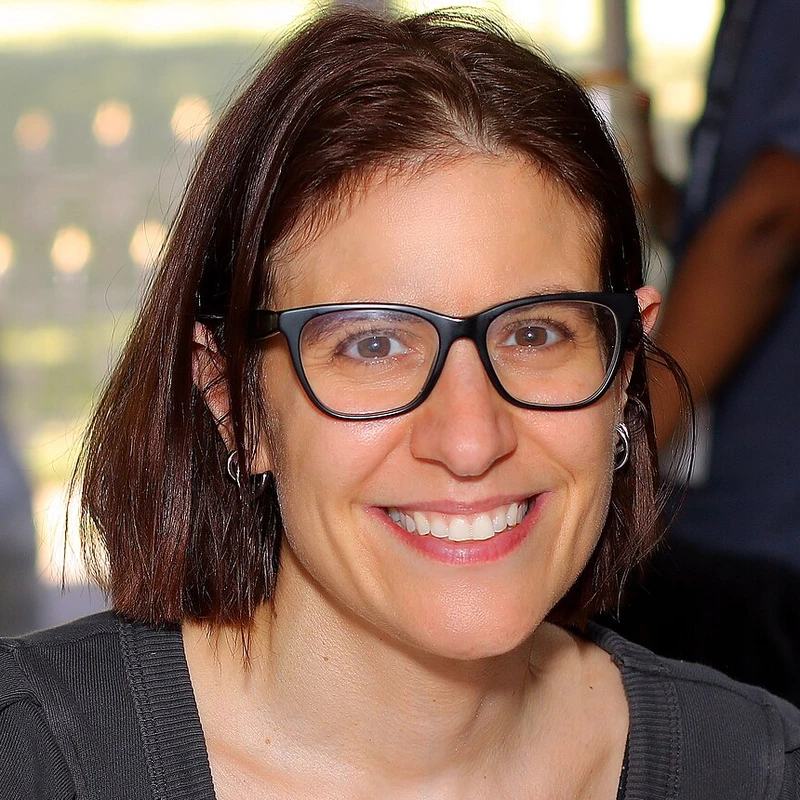 Foto da escritora Ali Hazelwood sorrindo, de óculos